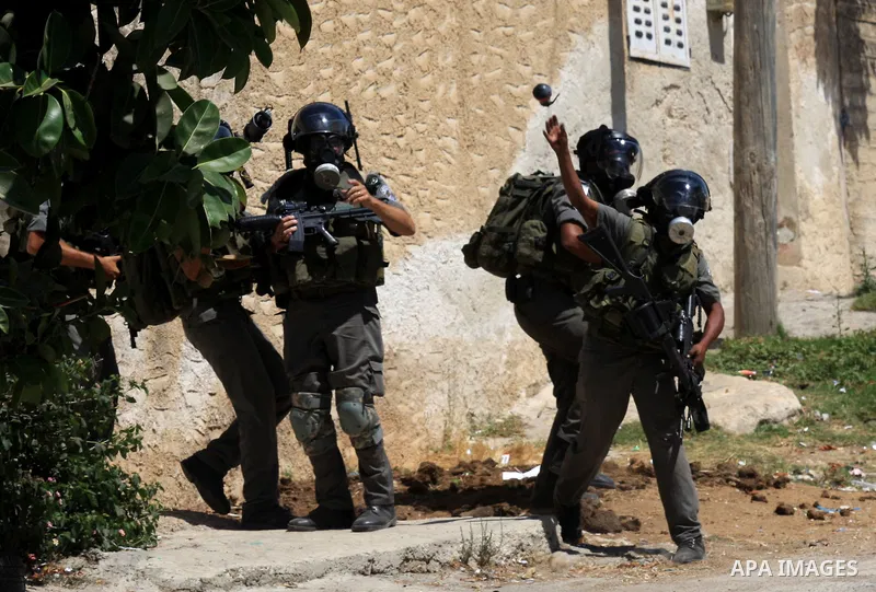 An Israeli border policeman throw a tear gas canister at Palestinian protesters during a demonstration against the expropriation of Palestinian land by Israel in the village of Kafr Qaddum, near the West Bank city of Nab...