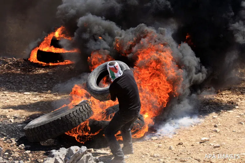 A Palestinian protester burn a tire during a demonstration against the expropriation of Palestinian land by Israel in the village of Kafr Qaddum, near the West Bank city of Nablus, on Sept. 14, 2012. Photo by Nedal Eshta...