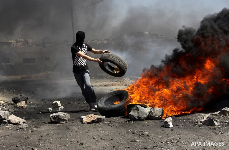 A Palestinian protester burn a tire during a demonstration against the expropriation of Palestinian land by Israel in the village of Kafr Qaddum, near the West Bank city of Nablus, on Sept. 14, 2012. Photo by Nedal Eshta...