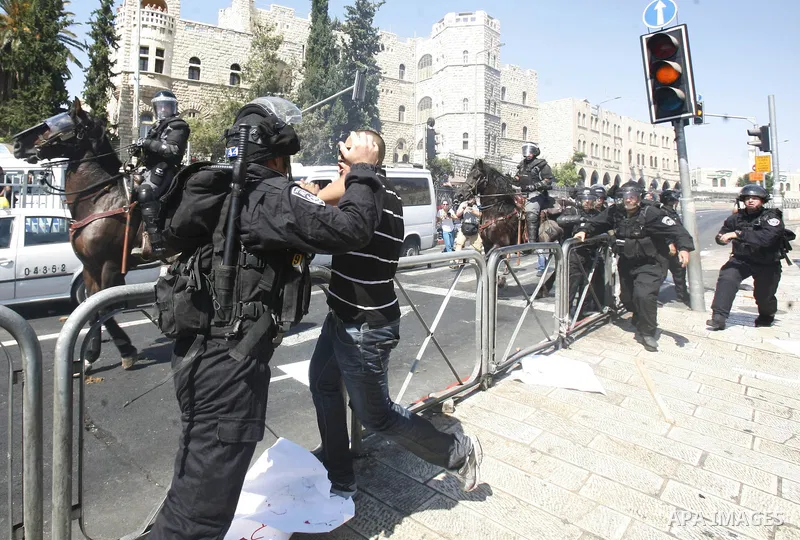 Israeli policeman clashes with a Palestinian protester during a demonstration against the controversial film 'Innocence of Muslims' in front of al-Aqsa Mosqe in Jerusalem, on September 14, 2012. The controversial low bud...