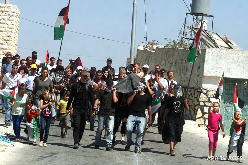 Palestinians and left-wing Israeli hold up Palestinian flags during a protest against the confiscation of Palestinian land to expand Jewish settlements in the West Bank village of Nabi Saleh near Ramallah on September 14...