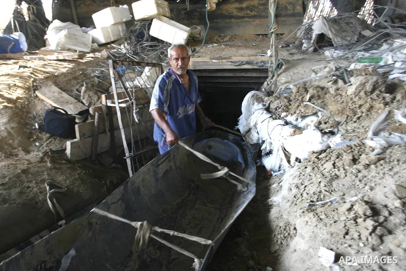 A Palestinian man works inside a tunnel used for smuggling goods, including food, fuel and building materials, along the Gaza-Egypt border in Rafah, in the southern Gaza Strip, on Sept. 15, 2012. The smuggling tunnels un...