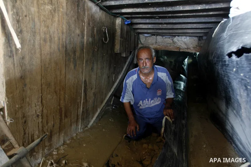 A Palestinian man works inside a tunnel used for smuggling goods, including food, fuel and building materials, along the Gaza-Egypt border in Rafah, in the southern Gaza Strip, on Sept. 15, 2012. The smuggling tunnels un...