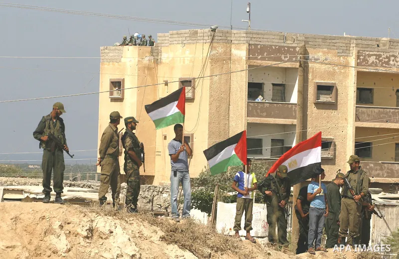 Palestinian children hold national flags and placards during a protest against the Egyptian decision to close the smuggling tunnels along the Gaza-Egypt border in Rafah, in the southern Gaza Strip, on Sept. 15, 2012. The...