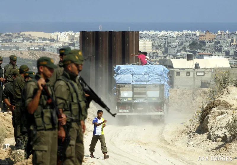 Palestinians ride a lorry carries building materials while Palestinian border police stand along the Gaza-Egypt border in Rafah, in the southern Gaza Strip, on Sept. 15, 2012. The tunnels trade, which analysts estimate i...