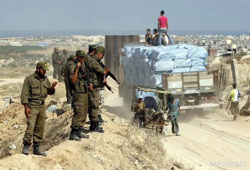 Palestinians ride a lorry carries building materials while Palestinian border police stand along the Gaza-Egypt border in Rafah, in the southern Gaza Strip, on Sept. 15, 2012. The tunnels trade, which analysts estimate i...