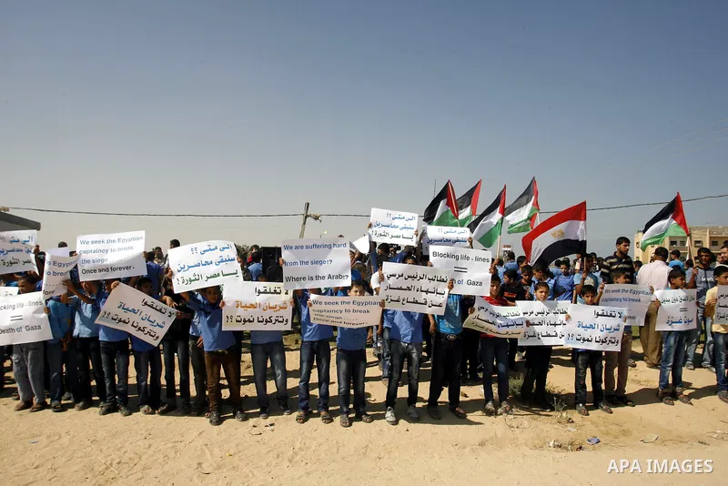 Palestinian children hold national flags and placards during a protest against the Egyptian decision to close the smuggling tunnels along the Gaza-Egypt border in Rafah, in the southern Gaza Strip, on Sept. 15, 2012. The...