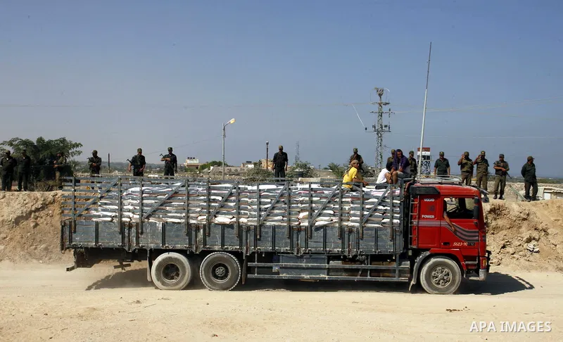 Palestinians ride a lorry carries building materials while Palestinian border police stand along the Gaza-Egypt border in Rafah, in the southern Gaza Strip, on Sept. 15, 2012. The tunnels trade, which analysts estimate i...