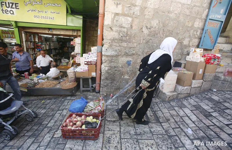 A Palestinian women drags fruit baskets at the market of Jerusalem's old city on Sept. 16, 2012. Photo by Mahfouz Abu Turk