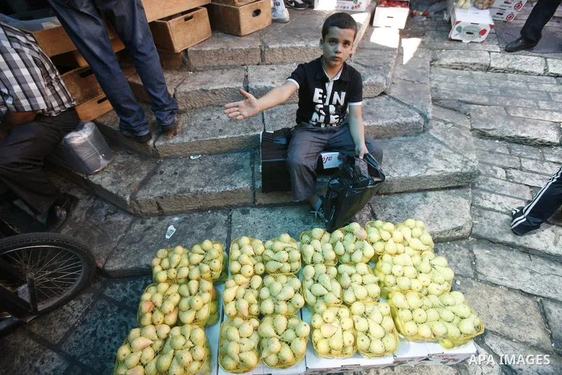 A Palestinian child sells pears at the market of Jerusalem's old city on Sept. 16, 2012. Photo by Mahfouz Abu Turk