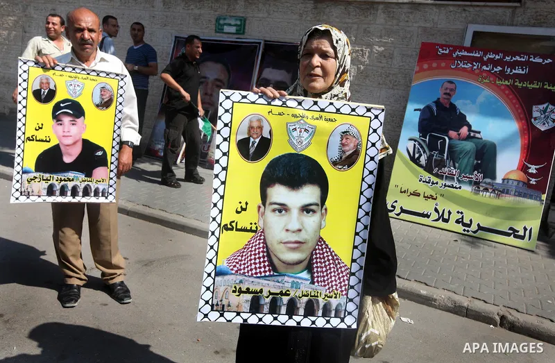 Palestinians hold a placard depicting jailed relatives during a protest in Gaza City calling for the release of Palestinian prisoners from Israeli jails September 17, 2012. Photo by Majdi Fathi