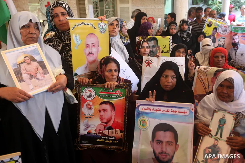 Palestinians hold a placard depicting jailed relatives during a protest in Gaza City calling for the release of Palestinian prisoners from Israeli jails September 17, 2012. Photo by Majdi Fathi