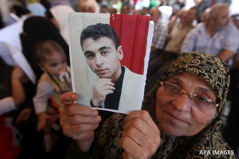 Palestinians hold a placard depicting jailed relatives during a protest in Gaza City calling for the release of Palestinian prisoners from Israeli jails September 17, 2012. Photo by Majdi Fathi