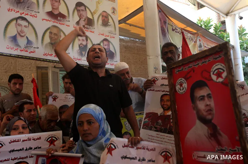 Palestinians hold a placard depicting jailed relatives during a protest in Gaza City calling for the release of Palestinian prisoners from Israeli jails September 17, 2012. Photo by Majdi Fathi