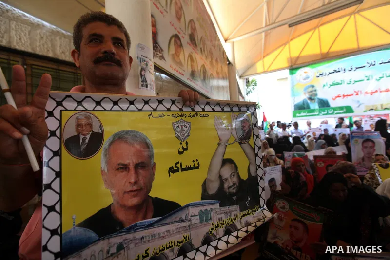 Palestinians hold a placard depicting jailed relatives during a protest in Gaza City calling for the release of Palestinian prisoners from Israeli jails September 17, 2012. Photo by Majdi Fathi