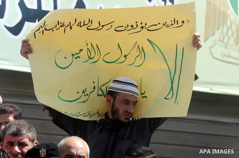 A Palestinian man holds up a banner during a peaceful sit-in in the West Bank city of Ramallah on September 17, 2012 against an anti-Islam film that has sparked violent demonstrations in the Muslim world. The low-budget,...