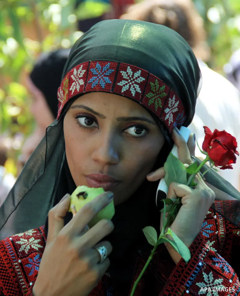 A Palestinian girl wears a traditional dress and eats a guava fruit, during the guava festival in the West Bank city of Qalqilya, Sept. 17, 2012. Photo by Nedal Eshtayah