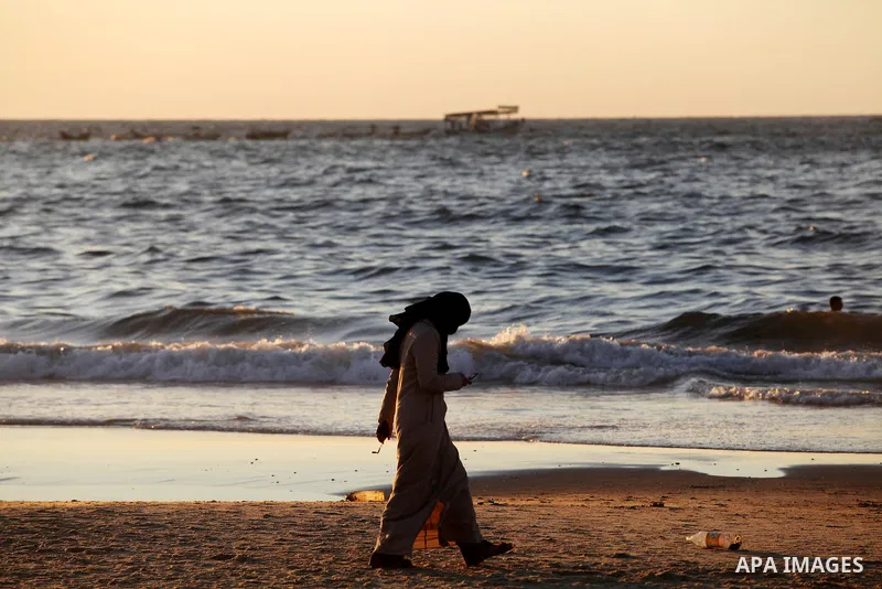 A Palestinian woman walks at the beach of Gaza city, Sept 17, 2012. Photo by Majdi Fathi