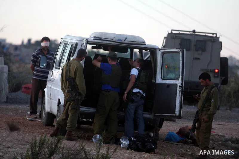 Israeli soldiers inspect a Palestinian car after detain the owner on the Atara checkpoint in the West Bank city of Ramallah on September 17, 2012. Photo by Issam Rimawi