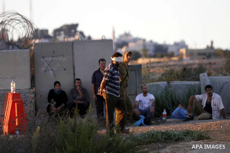 An Israeli soldier detains a Palestinian man on the Atara checkpoint in the West Bank city of Ramallah on September 17, 2012. Photo by Issam Rimawi