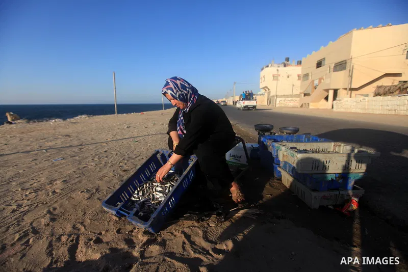 A Palestinian woman displays fish to sale it on the beach of Gaza city, Sept. 18, 2012 . Photo by Majdi Fathi