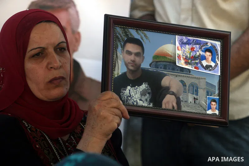 A Palestinian woman holds picture of prisoner held in Israeli jails during a sit-in outside the Red Crescent offices near the West Bank city of Ramallah on September 18, 2012 in solidarity with hunger-striking detainees...