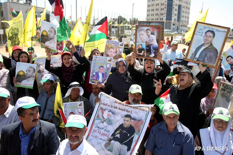 Palestinians hold portraits of relatives held in Israeli jails during a protest to calling for their liberty, in the West Bank city of Ramallah on September 19, 2012. Photo by Issam Rimawi