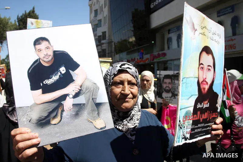 Palestinian women hold portraits of relatives held in Israeli jails during a protest to calling for their liberty, in the West Bank city of Ramallah on September 19, 2012. Photo by Issam Rimawi