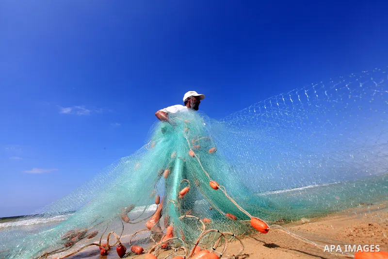A Palestinian fisherman prepares his trawl for fishing at the sea front in Deir al-Balah Palestinian refugee camp, central of Gaza Strip, on September 19, 2012. Photo by Majdi Fathi