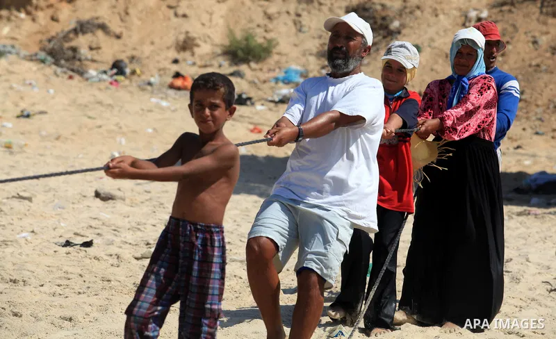 A Palestinian family work in fishing, tow their trawl from the sea in Deir al-Balah Palestinian refugee camp, central of Gaza Strip, on September 19, 2012. Photo by Majdi Fathi