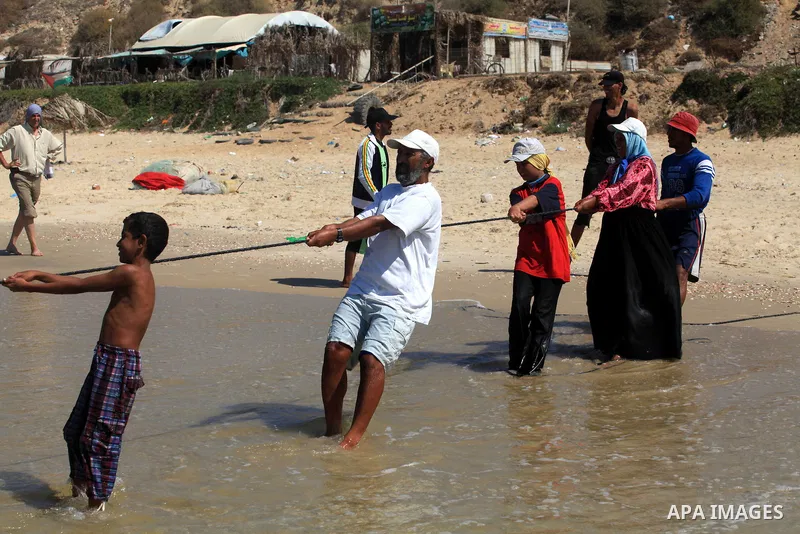 A Palestinian family work in fishing, tow their trawl from the sea in Deir al-Balah Palestinian refugee camp, central of Gaza Strip, on September 19, 2012. Photo by Majdi Fathi