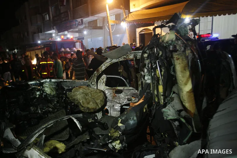 Palestinians gather around the wreckage of a car targeted by an Israeli aircraft in the town of Rafah in southern Gaza Strip on September 19, 2012. An Israeli air strike on the Gaza Strip killed two Palestinians and woun...