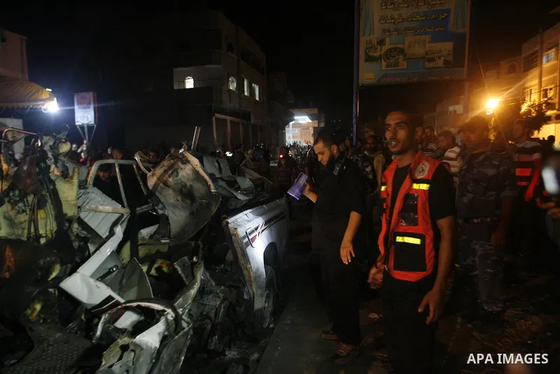 Palestinians gather around the wreckage of a car targeted by an Israeli aircraft in the town of Rafah in southern Gaza Strip on September 19, 2012. An Israeli air strike on the Gaza Strip killed two Palestinians and woun...