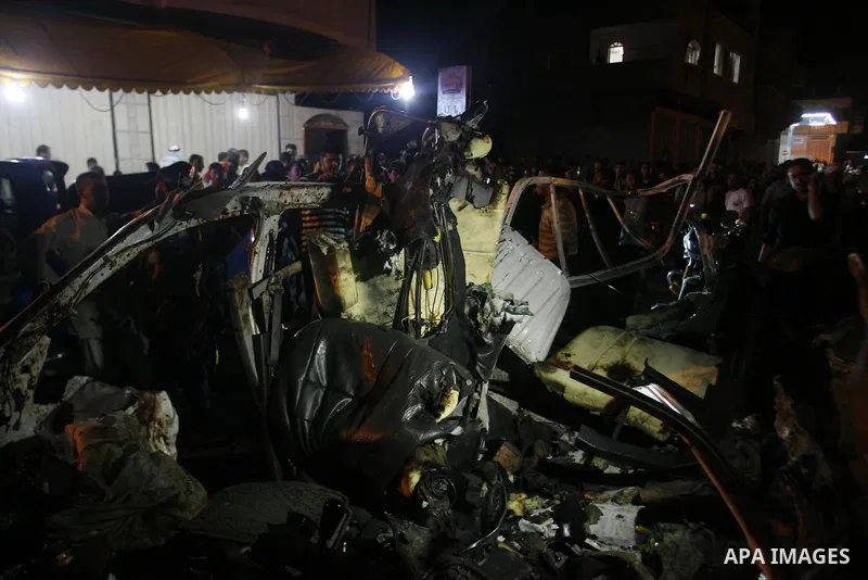 Palestinians gather around the wreckage of a car targeted by an Israeli aircraft in the town of Rafah in southern Gaza Strip on September 19, 2012. An Israeli air strike on the Gaza Strip killed two Palestinians and woun...