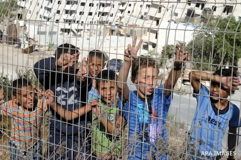 Palestinian refugee children stand behind the barrier during sealing off the Ras Khamis Checkpoint northen jerusalem on Sept. 20, 2012. The Israeli Ministry of Defence has announced its plans to seal off one of two check...