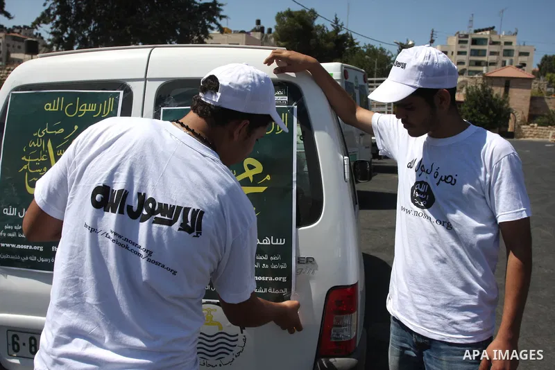 Palestinians paste posters on cars reading in Arabic "anyone but prophet Muhammad" during a campaign called by Palestinian activists against the anti-Islam movie entitled 'Innocence of Muslims' made in the U.S., in the W...