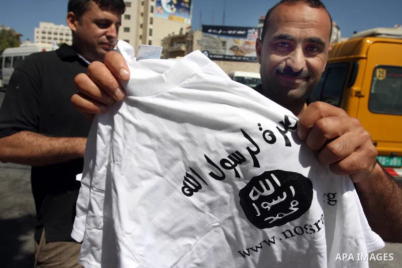 A Palestinian man displays a T-shirt reading in Arabic "Muhammad is the messenger of Allah" during a campaign called by Palestinian activists against the anti-Islam movie entitled 'Innocence of Muslims' made in the U.S.,...