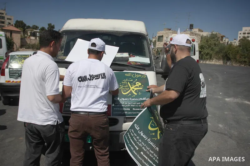 Palestinians paste posters on cars reading in Arabic "anyone but prophet Muhammad" during a campaign called by Palestinian activists against the anti-Islam movie entitled 'Innocence of Muslims' made in the U.S., in the W...