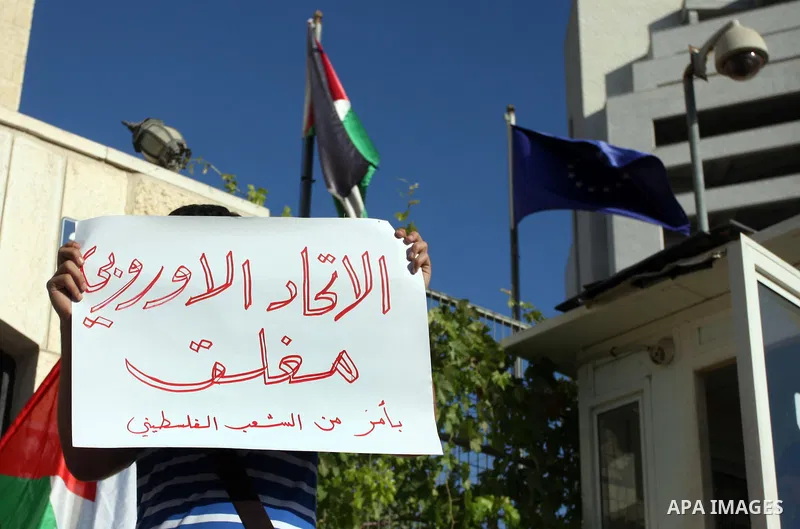 A Palestinian activist holds a placard reading in Arabic "EU Closed, by order of Palestinians" during a protest refusal to the policy of European Union toward Palestinian issue and the prisoners in the Israeli jails, in...