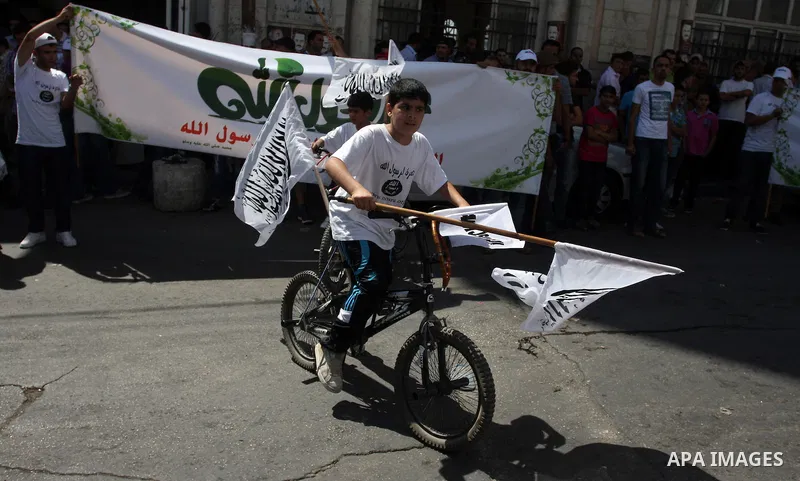 A Palestinian boy rides his bicycle and waves a flags during a protest in the West Bank town of Ramallah against an anti-Islam movie made in the U.S. and French cartoons said to insult the Prophet Muhammad, 21 September...