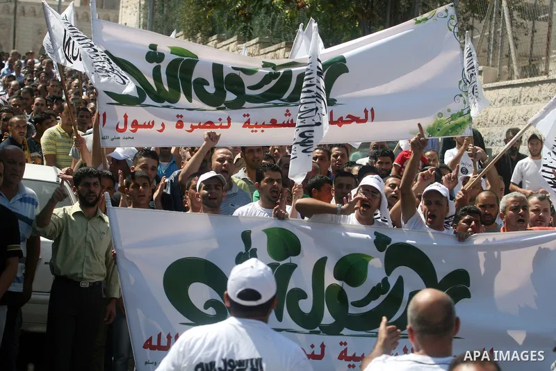 Palestinian protesters shout slogans and wave flags during a protest in the West Bank town of Ramallah against an anti-Islam movie made in the U.S. and French cartoons said to insult the Prophet Muhammad, 21 September 20...