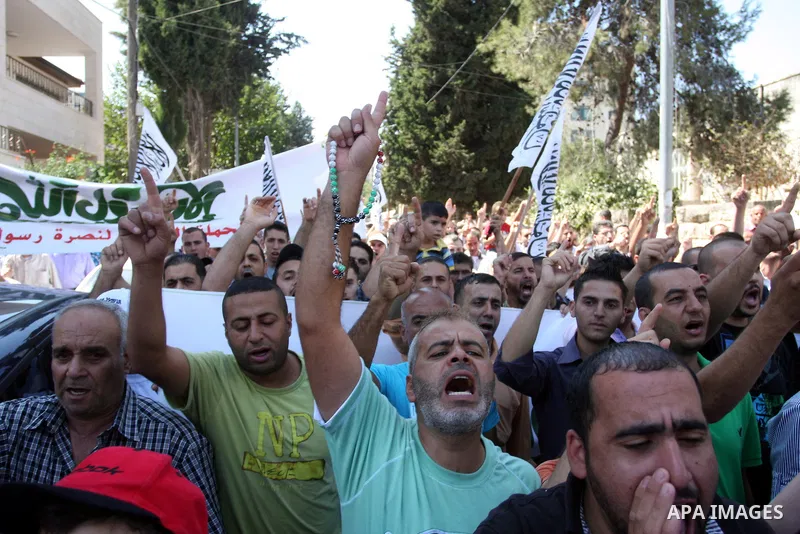 Palestinian protesters shout slogans and wave flags during a protest in the West Bank town of Ramallah against an anti-Islam movie made in the U.S. and French cartoons said to insult the Prophet Muhammad, 21 September 20...