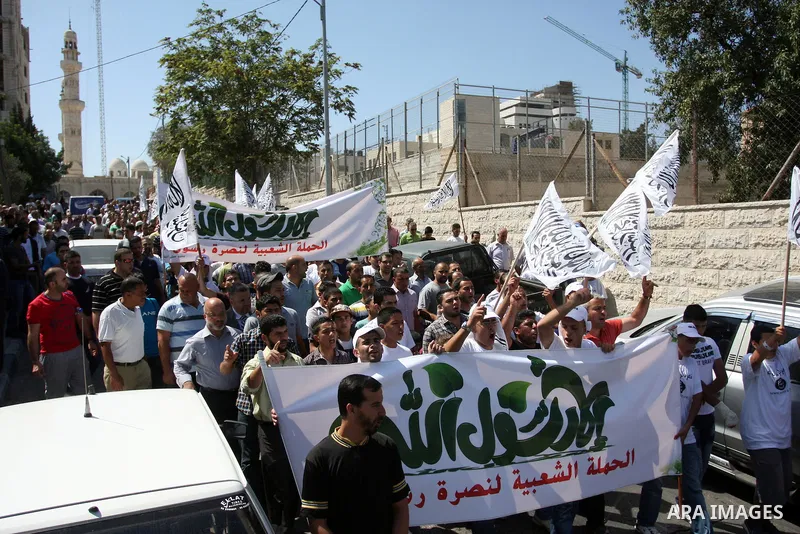 Palestinian protesters shout slogans and wave flags during a protest in the West Bank town of Ramallah against an anti-Islam movie made in the U.S. and French cartoons said to insult the Prophet Muhammad, 21 September 20...