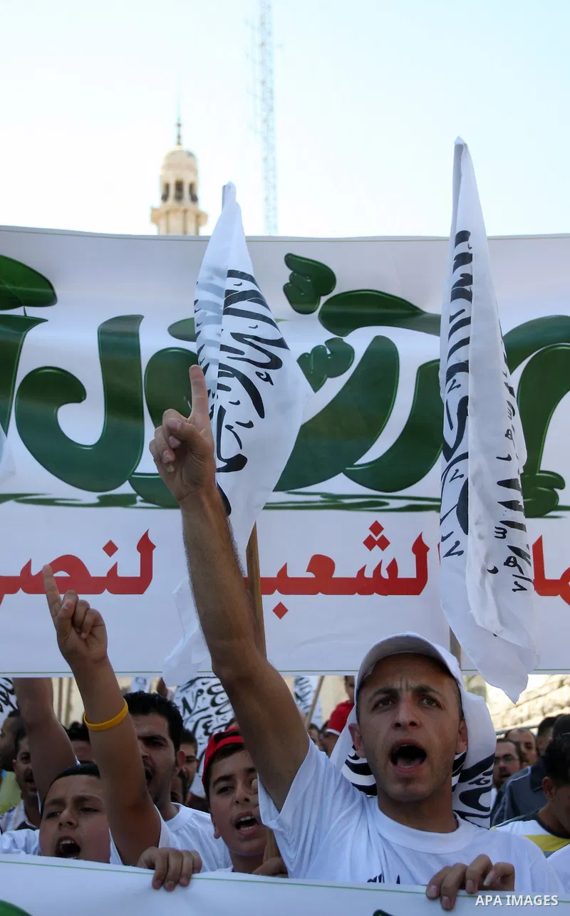 Palestinian protesters shout slogans and wave flags during a protest in the West Bank town of Ramallah against an anti-Islam movie made in the U.S. and French cartoons said to insult the Prophet Muhammad, 21 September 20...