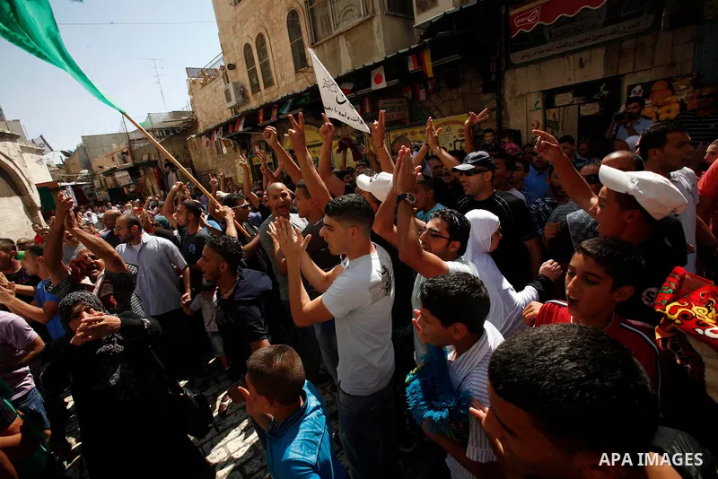 Palestinians wave flags and shout slogans during a protest against an anti-Islam movie made in the U.S. and French cartoons said to insult the Prophet Muhammad in Jerusalem's Old City, Sept. 21, 2012. Photo by Mahfouz Ab...