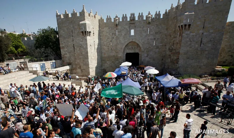Palestinians wave flags and shout slogans during a protest against an anti-Islam movie made in the U.S. and French cartoons said to insult the Prophet Muhammad in Jerusalem's Old City, Sept. 21, 2012. Photo by Mahfouz Ab...