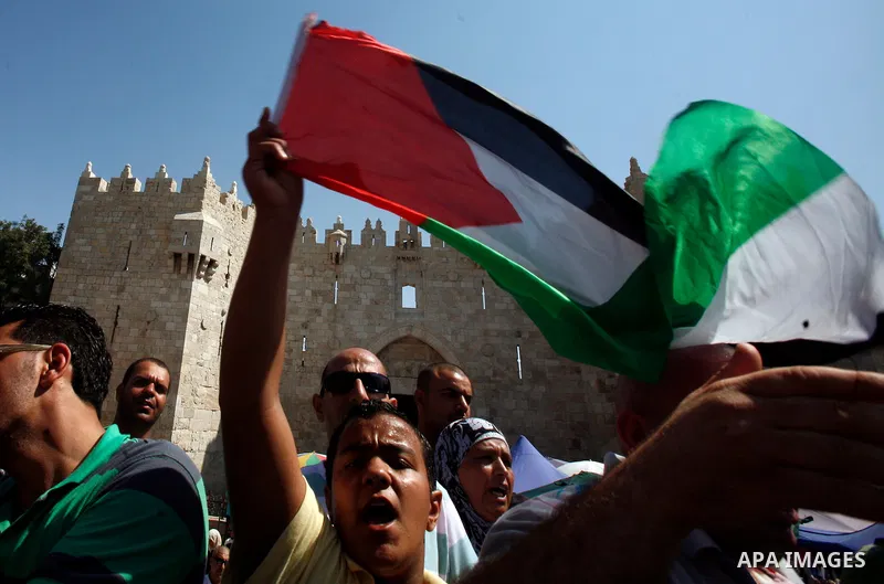 Palestinians wave flags and shout slogans during a protest against an anti-Islam movie made in the U.S. and French cartoons said to insult the Prophet Muhammad in Jerusalem's Old City, Sept. 21, 2012. Photo by Mahfouz Ab...