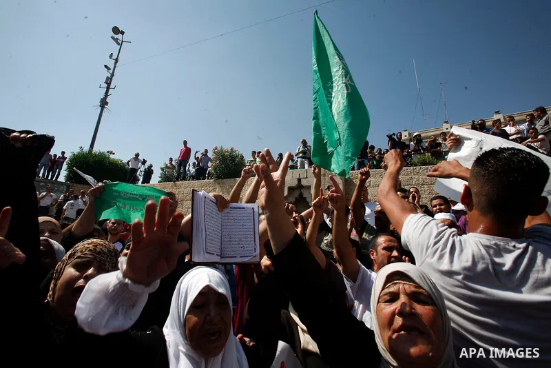 Palestinians wave flags and shout slogans during a protest against an anti-Islam movie made in the U.S. and French cartoons said to insult the Prophet Muhammad in Jerusalem's Old City, Sept. 21, 2012. Photo by Mahfouz Ab...