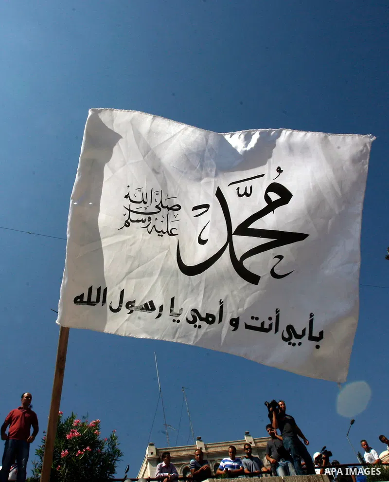 Palestinians wave flags and shout slogans during a protest against an anti-Islam movie made in the U.S. and French cartoons said to insult the Prophet Muhammad in Jerusalem's Old City, Sept. 21, 2012. Photo by Mahfouz Ab...