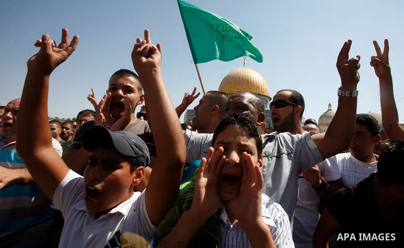 Palestinians wave flags and shout slogans during a protest against an anti-Islam movie made in the U.S. and French cartoons said to insult the Prophet Muhammad in Jerusalem's Old City, Sept. 21, 2012. Photo by Mahfouz Ab...